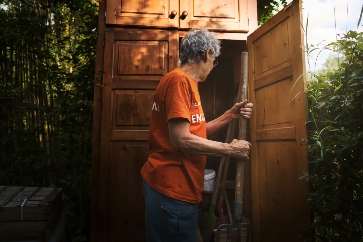Une femme ouvre la porte d’une cabane en bois